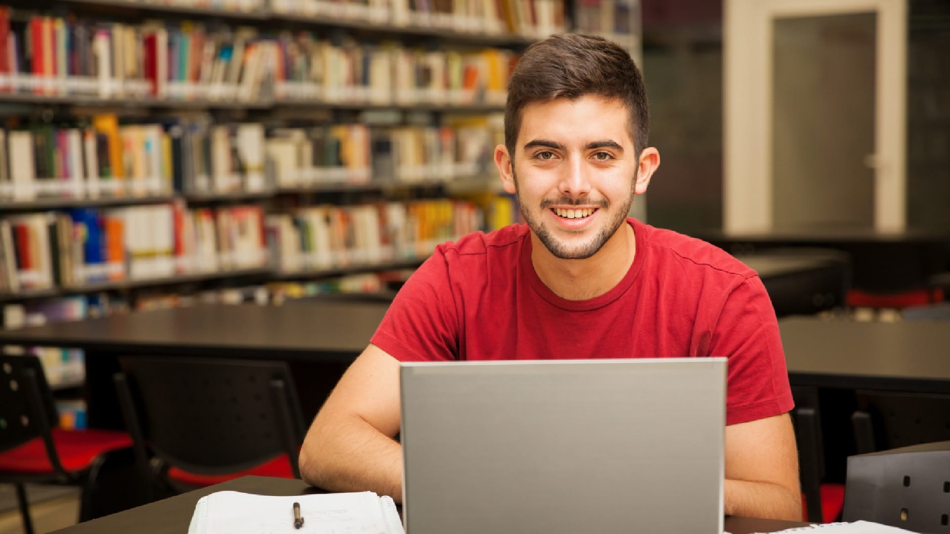 portrait-attractive-latin-student-doing-some-school-work-with-laptop-library